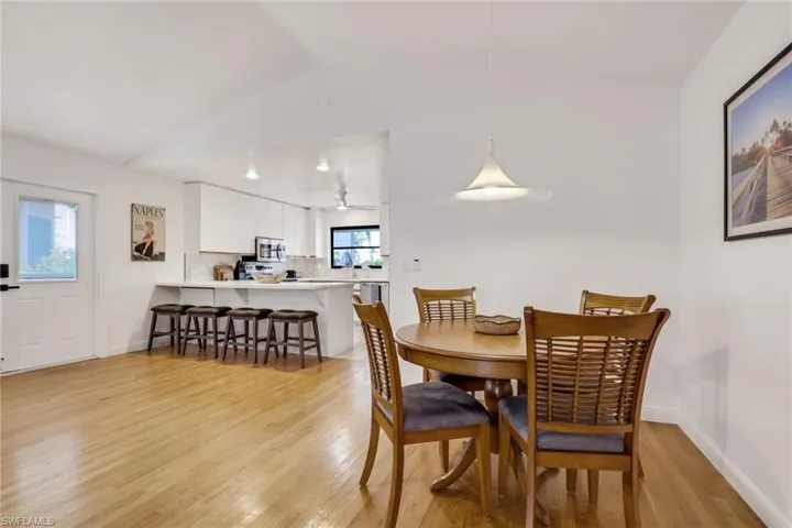 Dining room featuring light wood-style flooring and vaulted ceiling