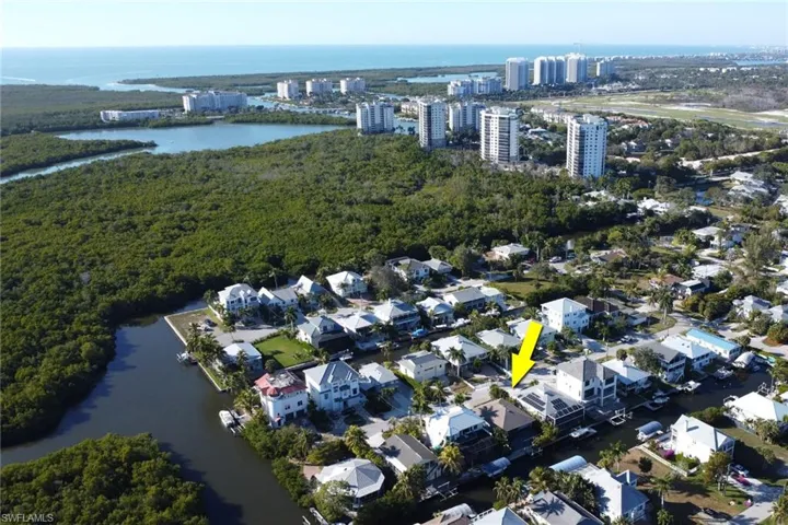 Aerial view of property and surrounding area featuring a large body of water and nearby urban area
