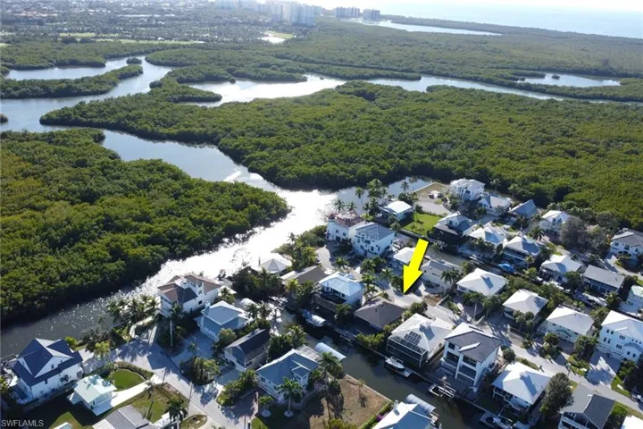 Aerial view of property's location with a nearby body of water and a heavily wooded area
