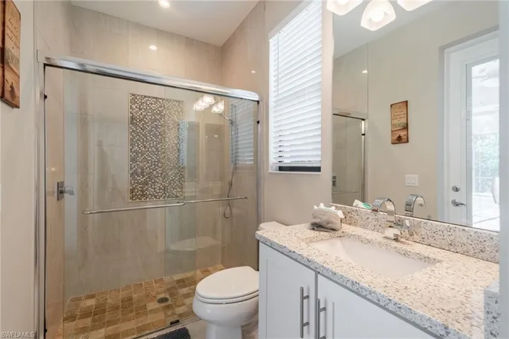 Bathroom off bedroom with access to pool area.