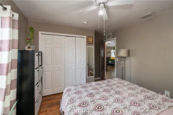 Bedroom with a closet, ceiling fan, and dark hardwood / wood-style floors