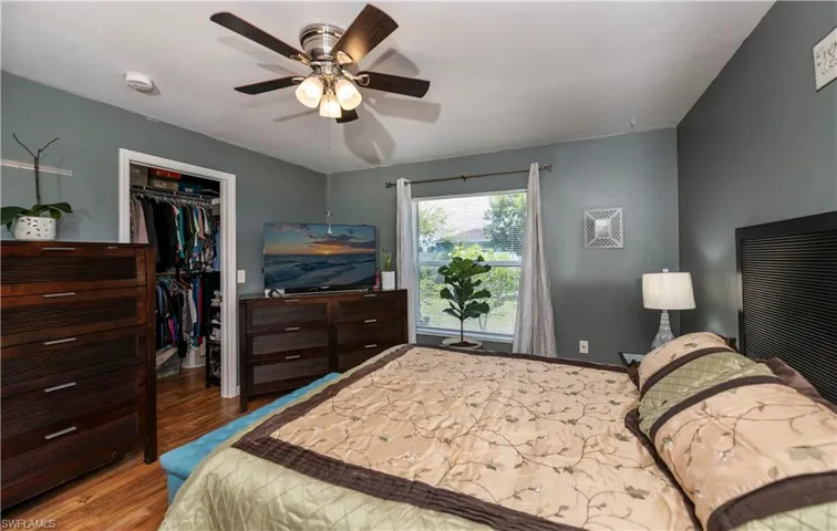 Bedroom featuring a spacious closet, a closet, ceiling fan, and hardwood / wood-style flooring