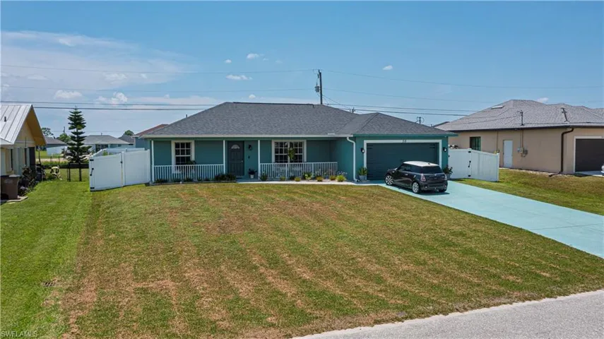 Single story home featuring a front lawn, a porch, and a garage