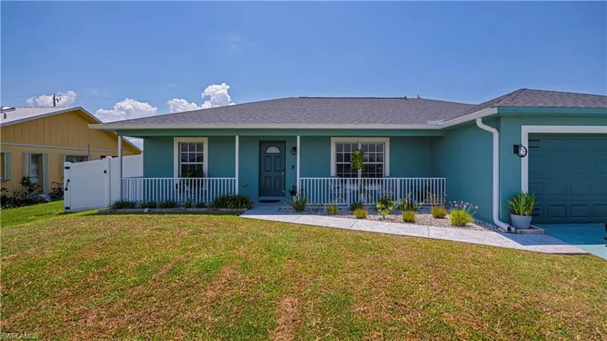 Single story home featuring a garage and a front lawn