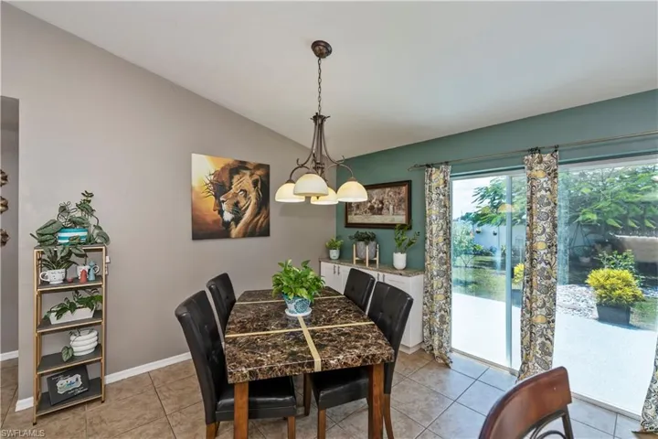 Dining area featuring tile patterned floors and lofted ceiling