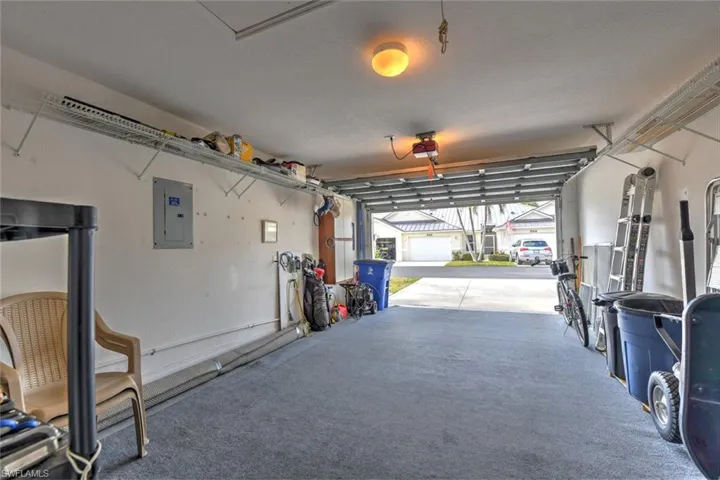 Garage featuring a garage door opener and electric panel