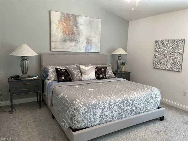 Bedroom featuring carpet floors and vaulted ceiling