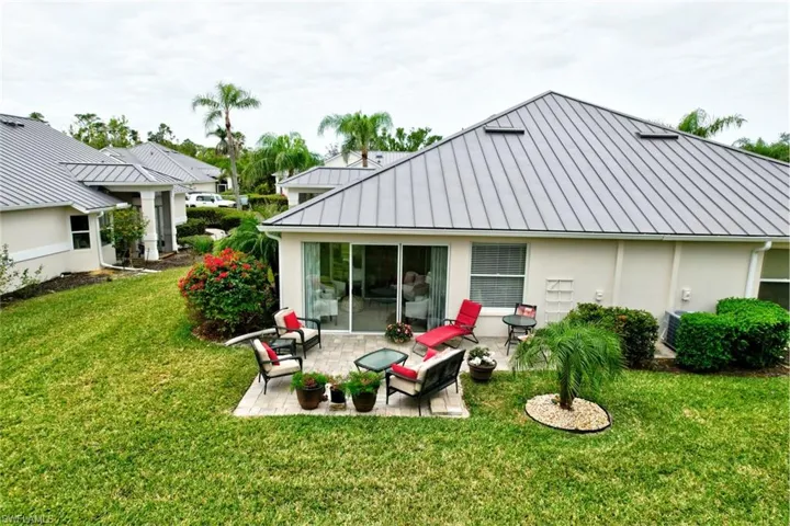 Rear view of house with a patio area and a lawn