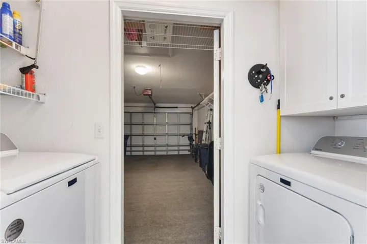 Laundry area featuring independent washer and dryer, cabinets, and carpet flooring