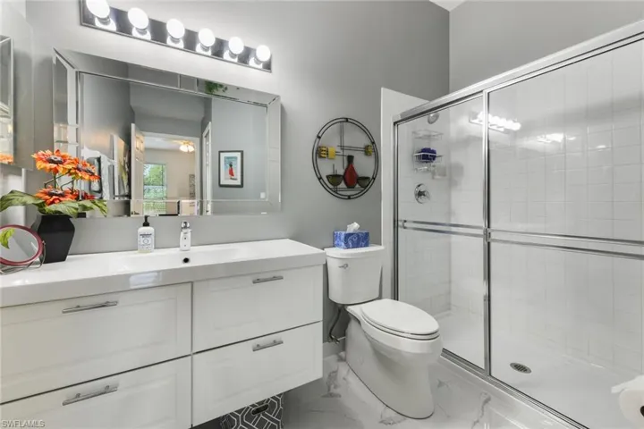 Bathroom with an enclosed shower, vanity, and toilet