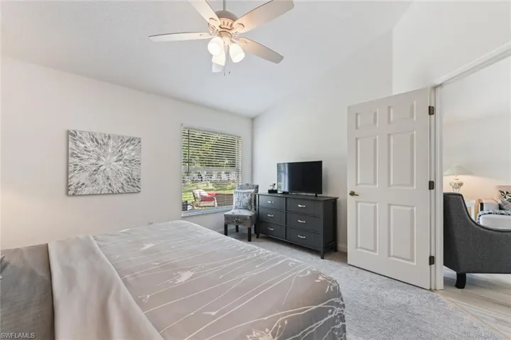 Bedroom with ceiling fan, vaulted ceiling, and carpet