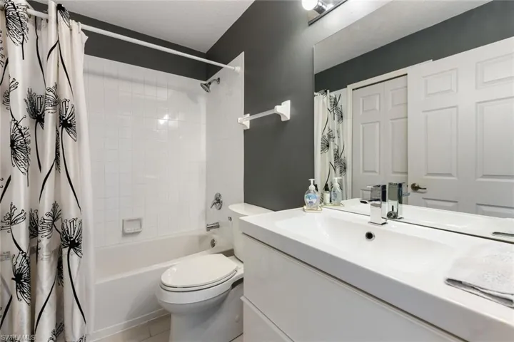 Full bathroom featuring shower / tub combo with curtain, vanity, and toilet