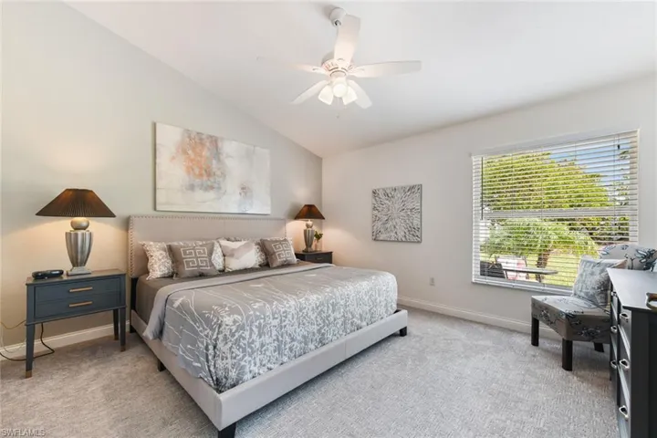 Bedroom featuring lofted ceiling, light carpet, and ceiling fan