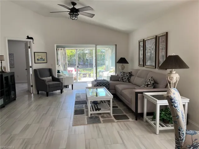 Living room featuring vaulted ceiling and ceiling fan
