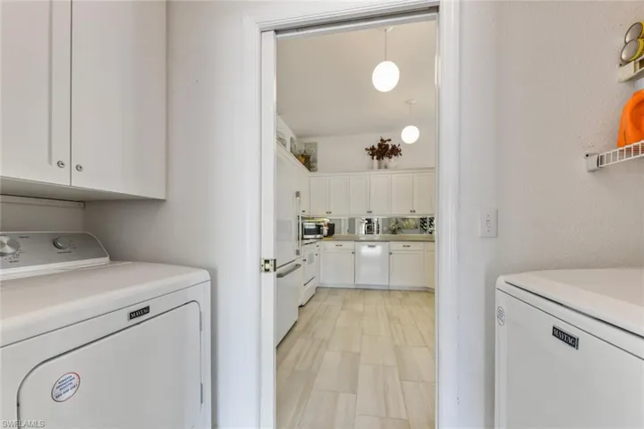 Clothes washing area featuring cabinets and independent washer and dryer