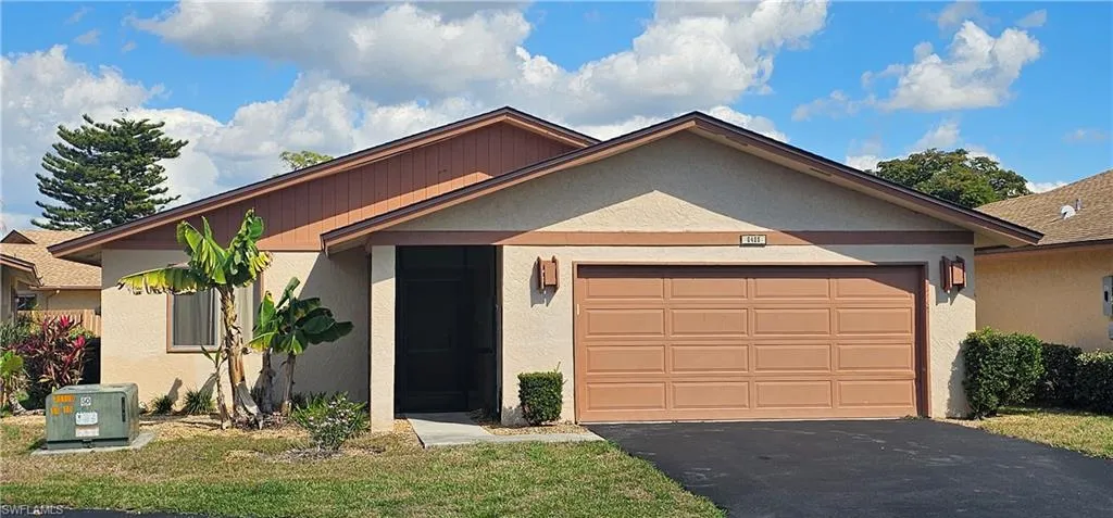 View of front of property with a garage and a front lawn