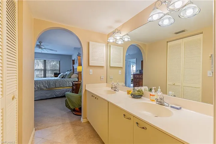 Bathroom with dual vanity, tile patterned flooring, and ceiling fan