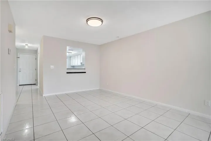 Empty room with light tile patterned floors and baseboards