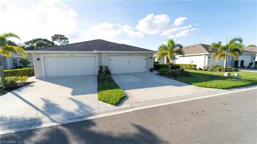 Ranch-style house featuring stucco siding, driveway, and a front lawn