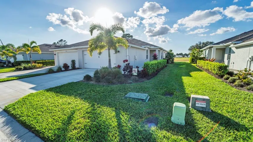 View of home's exterior featuring stucco siding, driveway, a garage, and a lawn
