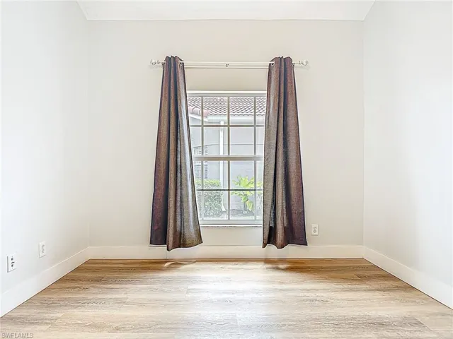 Unfurnished room with light wood-style floors and baseboards