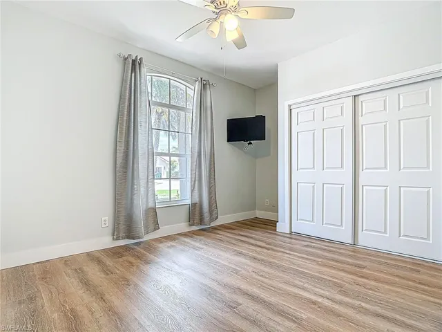 Unfurnished bedroom with baseboards, ceiling fan, a closet, and light wood-type flooring