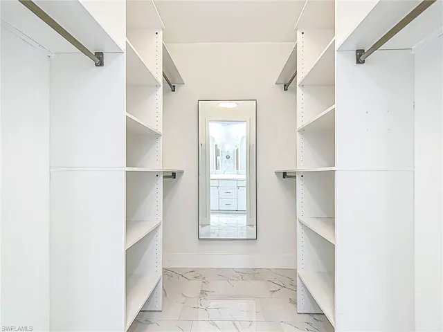 Walk in closet with marble finish floor