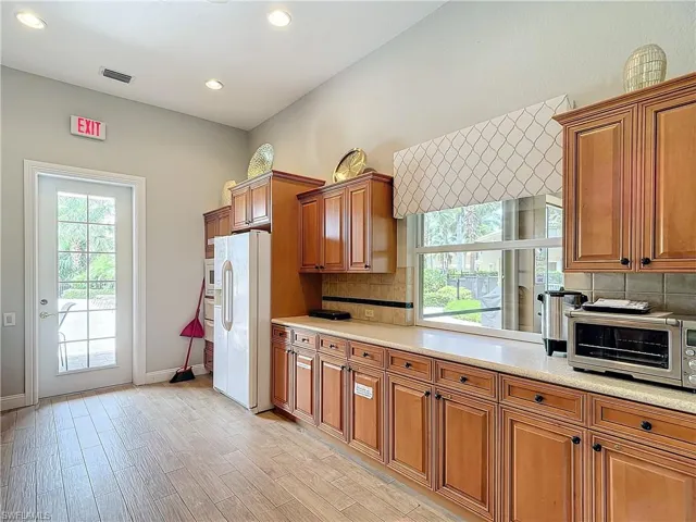 Kitchen featuring backsplash, white refrigerator with ice dispenser, and light hardwood / wood-style flooring