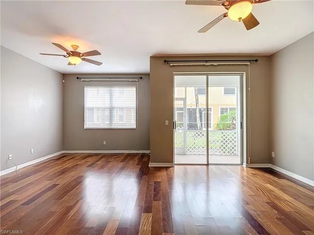 Spare room featuring a wealth of natural light, hardwood / wood-style flooring, and ceiling fan