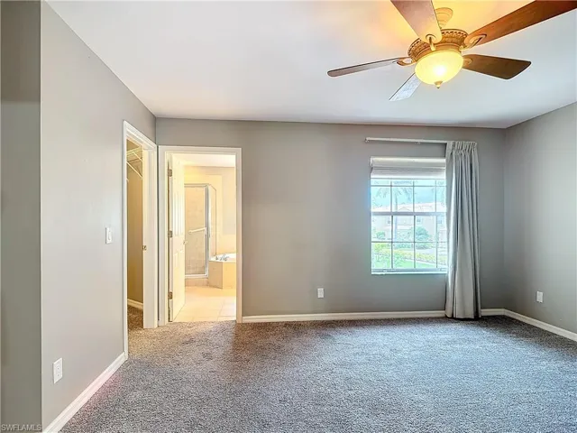 Carpeted empty room featuring ceiling fan