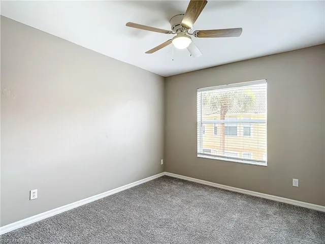 Spare room featuring carpet flooring and ceiling fan