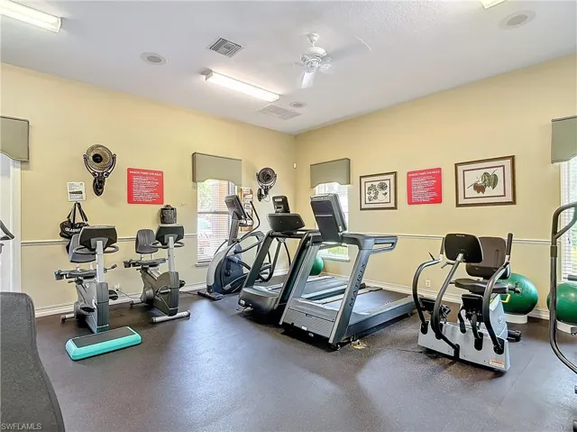 Exercise room with ceiling fan and a textured ceiling