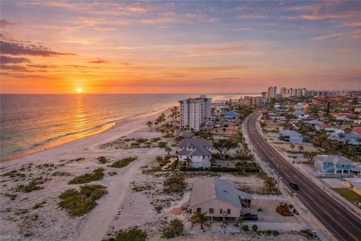 Aerial view at dusk of view of water and beach and a view of city