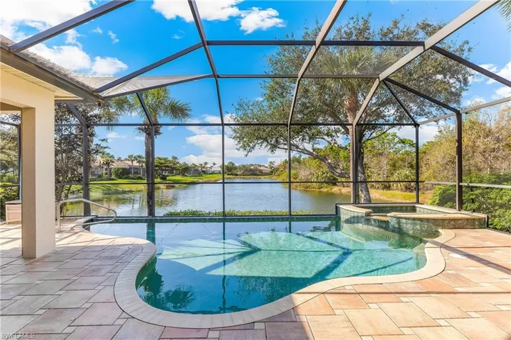 Pool and hot tub with beautiful pool deck and lake view.