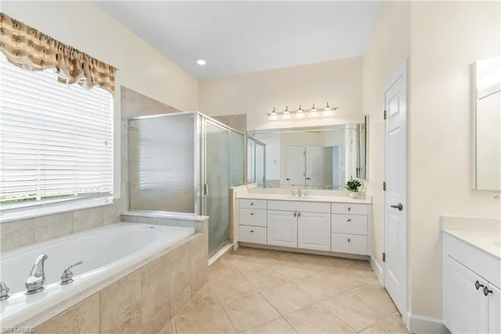 Main bathroom with tub and shower and dual sinks.