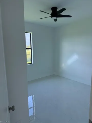 Unfurnished room featuring a ceiling fan and light tile patterned floors