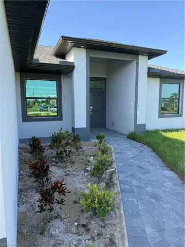 View of exterior entry featuring stucco siding