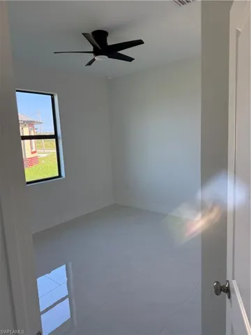 Spare room with light tile patterned floors and ceiling fan