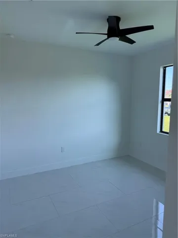Unfurnished room featuring ceiling fan and light tile patterned floors