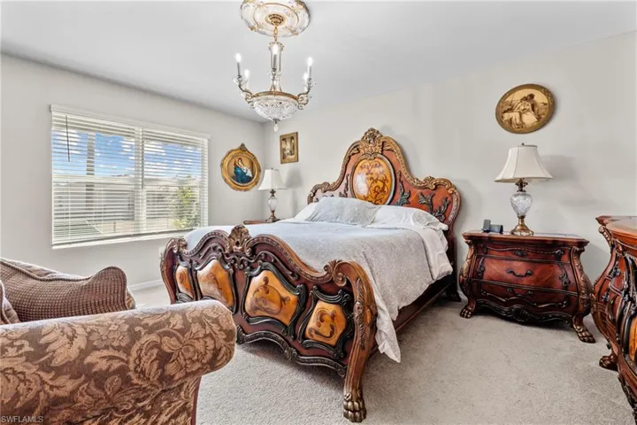 Carpeted bedroom featuring hanging lights