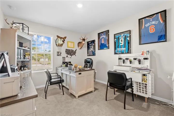 Home office with light carpet and baseboards
