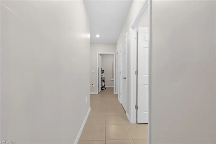 Hall featuring baseboards and light tile patterned flooring