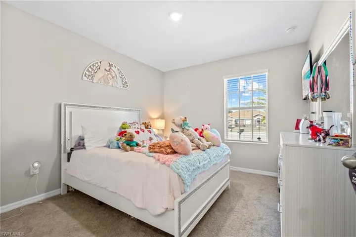 Bedroom with baseboards and light colored carpet