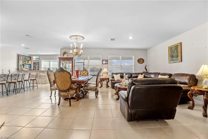 Living area featuring suspended lighting, light tile patterned flooring, and plenty of natural light