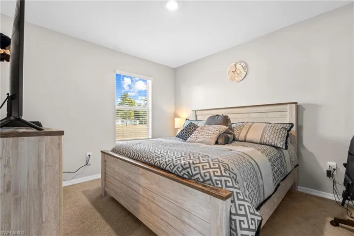 Bedroom featuring light colored carpet and baseboards