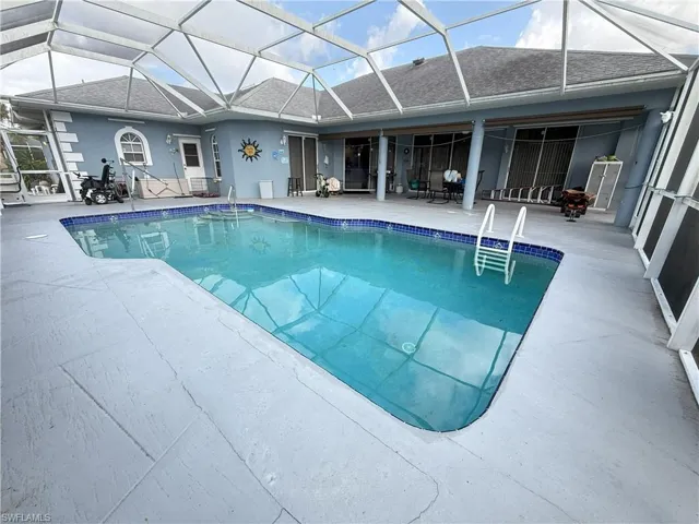 View of swimming pool with a patio and a lanai