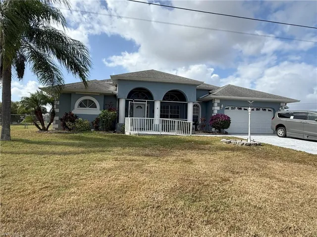 Ranch-style home with a porch, a garage, and a front lawn