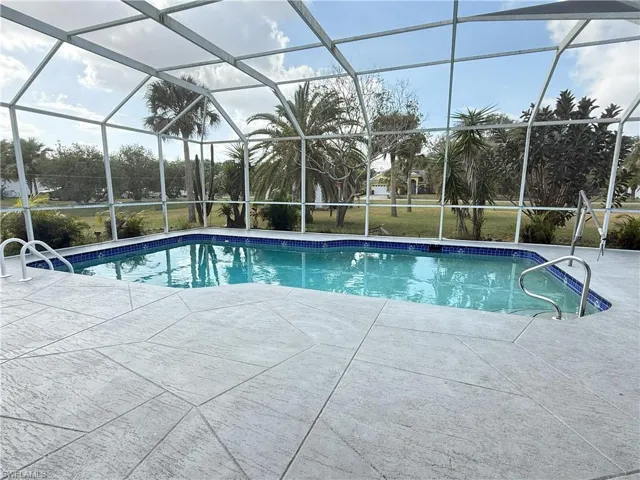 View of swimming pool with a patio and a lanai