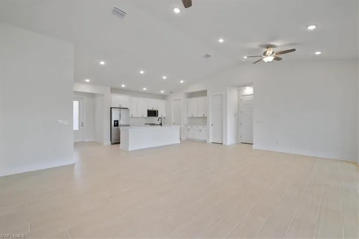 Unfurnished living room with recessed lighting, ceiling fan, lofted ceiling, and wood finish floors