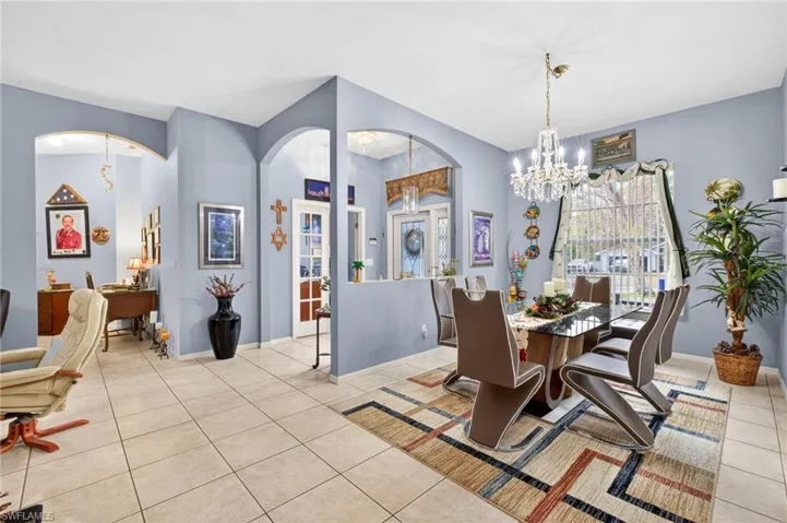 Dining room featuring hanging lights, light tile patterned flooring, and arched walkways